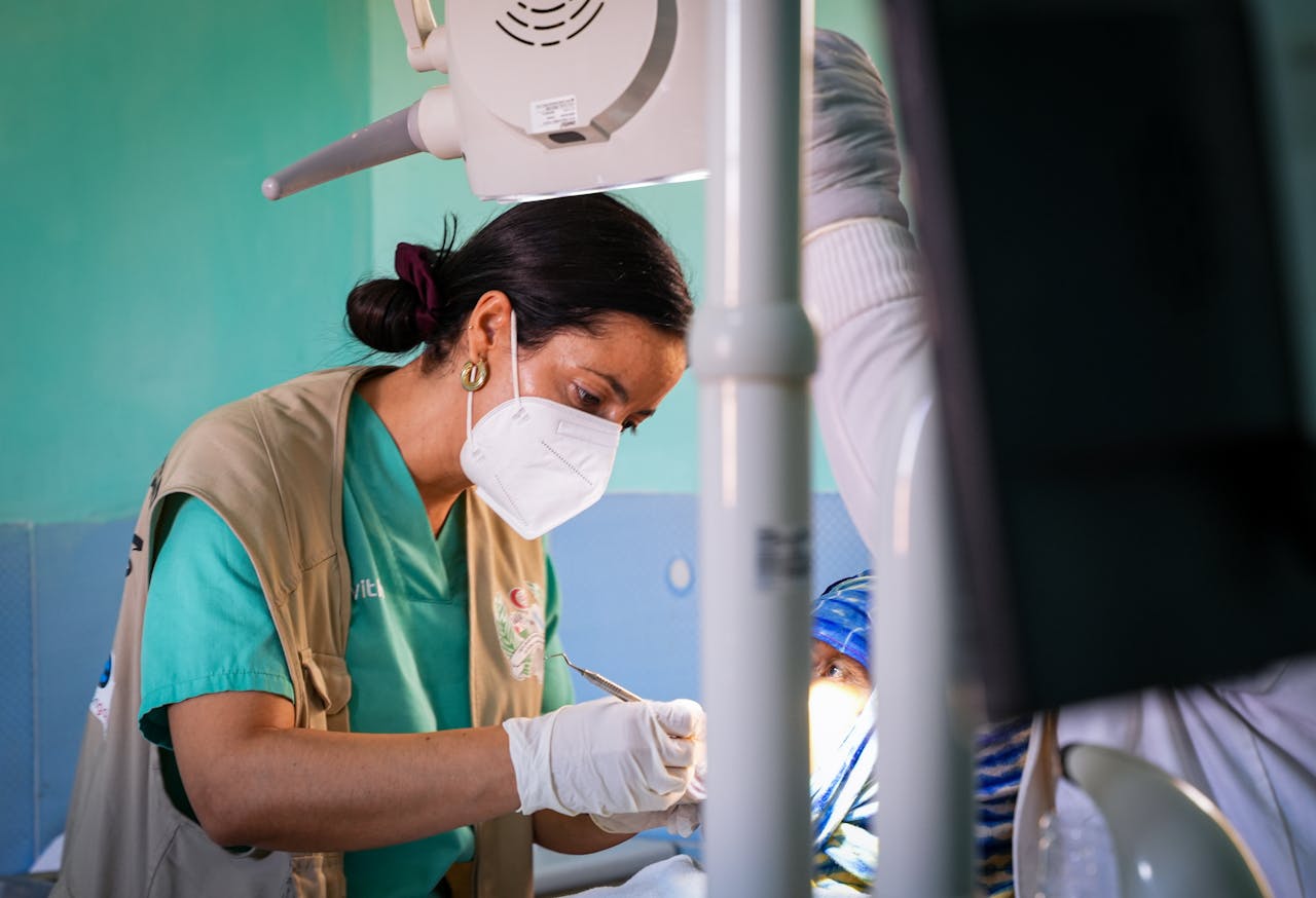 A female doctor works attentively on a medical procedure in an indoor setting, showcasing healthcare professionalism.